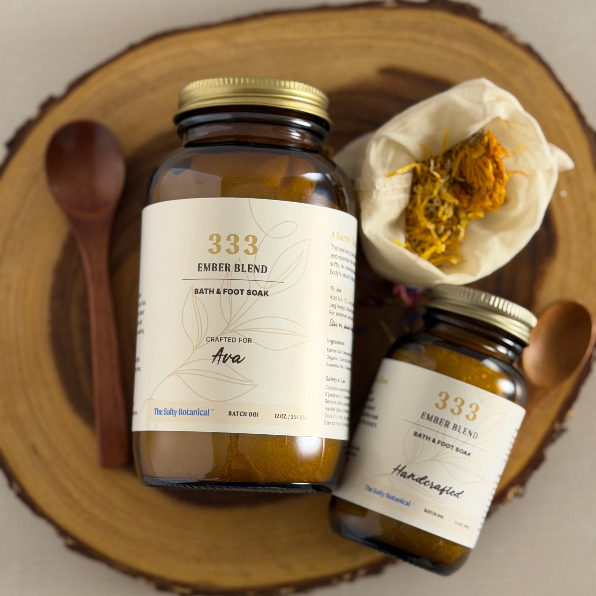 Two jars of 333 Ember blend bath and body products on a wooden surface.